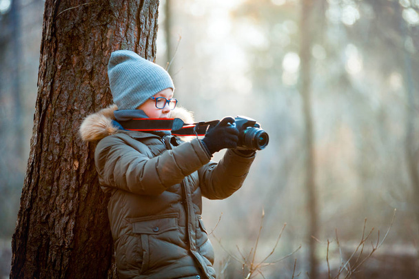 Boy using digital camera taking photo in the nature, hobby concept - Фото, изображение