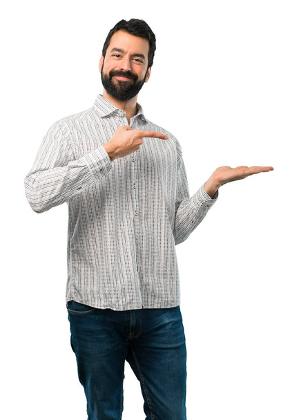 Handsome man with beard holding copyspace imaginary on the palm - Foto, immagini