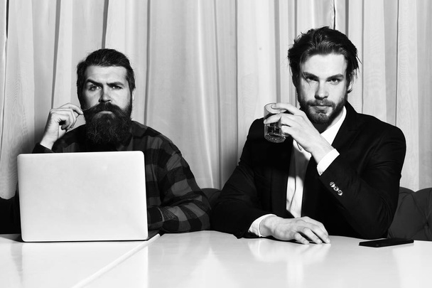 hombres barbudos, hombres de negocios con vaso de whisky, portátil y teléfono - Foto, Imagen