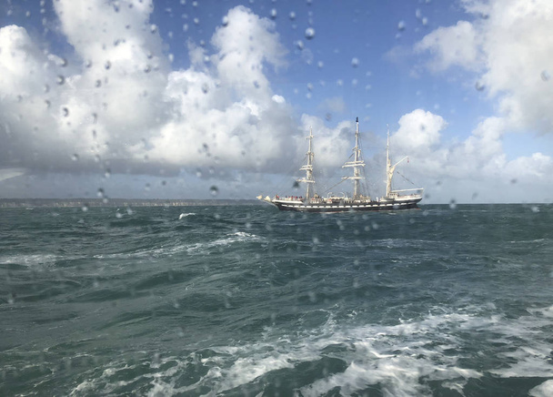 Pohled na moře a loď přes okno s kapkami deště - Fotografie, Obrázek