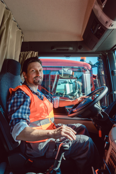 Conductor de camión o camión sentado en la cabina de su vehículo
 - Foto, imagen