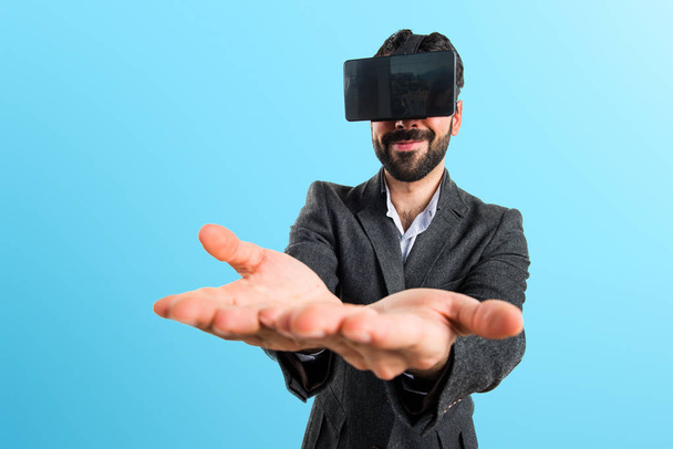 Uomo che usa occhiali VR con qualcosa in mano
 - Foto, immagini