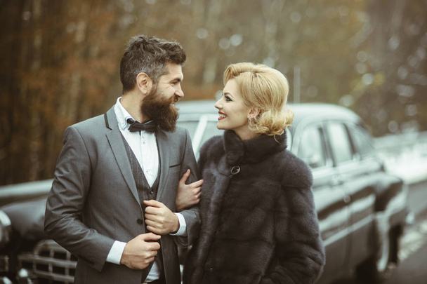 Boldogan élvezi egy szép napon outdoorsat házaspár antik autó, jóképű, gazdag ember és a gyönyörű nő pózol kint, az emberek időt együtt - Fotó, kép