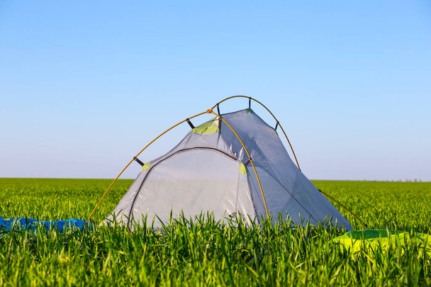 closeup white touristic tent  among a green fields - Φωτογραφία, εικόνα