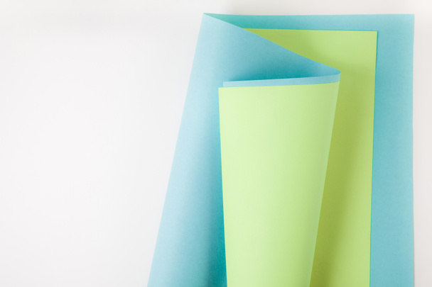 blue and green paper sheets on grey background - Φωτογραφία, εικόνα
