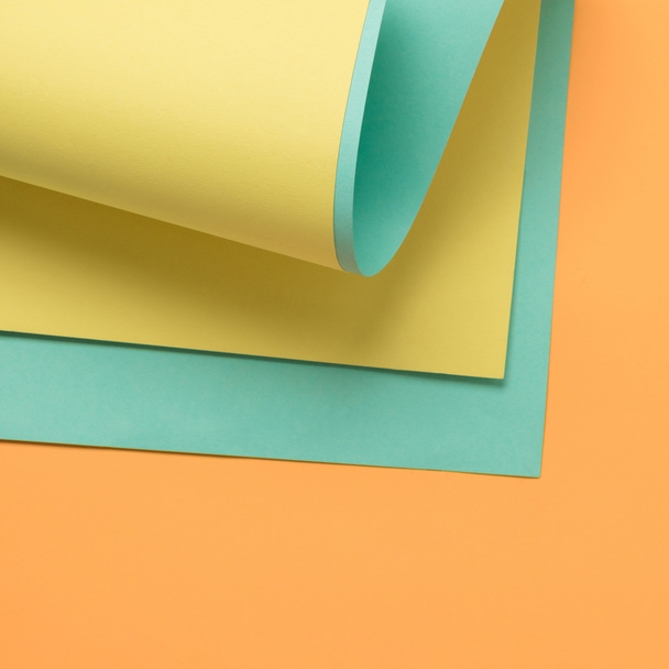 mooie creatieve achtergrond met gele, groene en oranje gekleurd papier - Foto, afbeelding