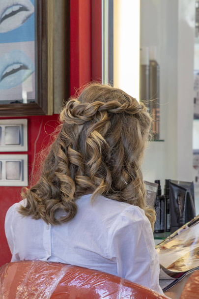 chica que acaba de ser hecho bucles en su cabello antes de la comunión por estilista profesional
 - Foto, Imagen