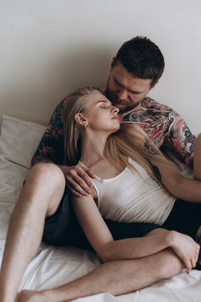 Sensual girl leaning with eyes closed on tattooed man - Valokuva, kuva