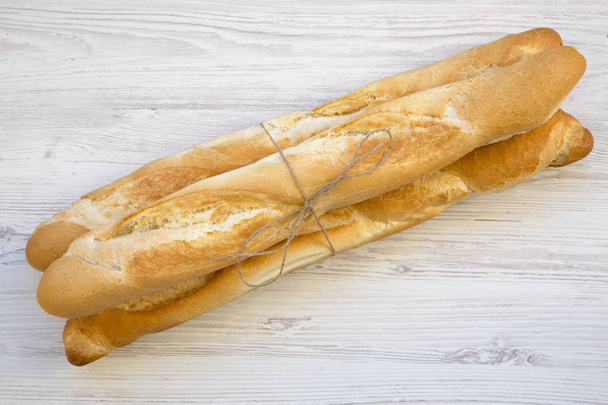 Beyaz ahşap zemin, üzerine taze baget ekmek en iyi görünümü. - Fotoğraf, Görsel