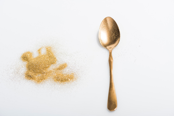golden spoon and bright glitter isolated on white - Foto, Bild