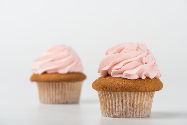 two tasty cooked pink cupcakes on white - Фото, изображение