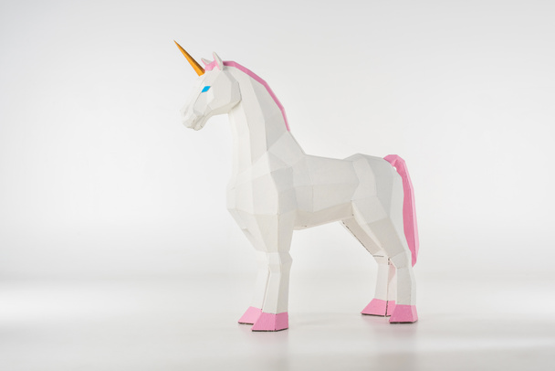 jouet licorne avec corne dorée avec sabots roses sur blanc
 - Photo, image