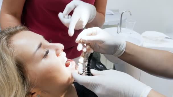 Imágenes 4k del dentista comprobando el color de los dientes de los pacientes antes del procedimiento de blanqueamiento
 - Metraje, vídeo