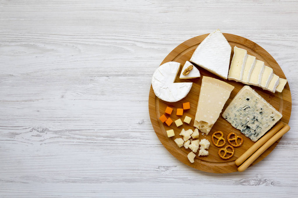 Tasting delicious cheese with  walnuts, bread sticks and pretzels on wooden background, top view. Food for romantic. From above. Flat lay. Copy space. - Photo, Image