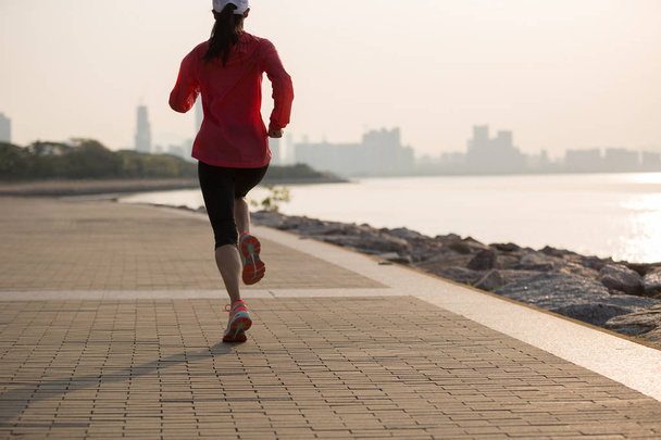sportos fiatal fitness nő a napfelkelte parton nyomvonal futó - Fotó, kép