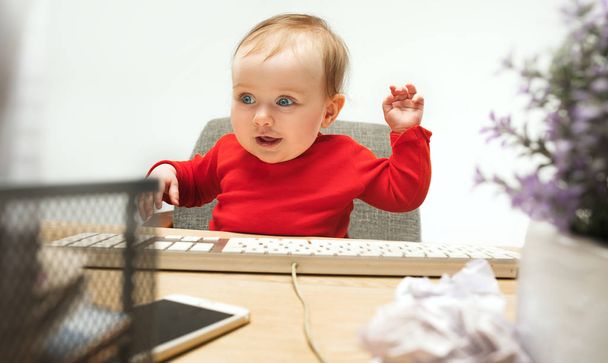 Happy child baby girl toddler sitting with keyboard of computer isolated on a white background - Valokuva, kuva