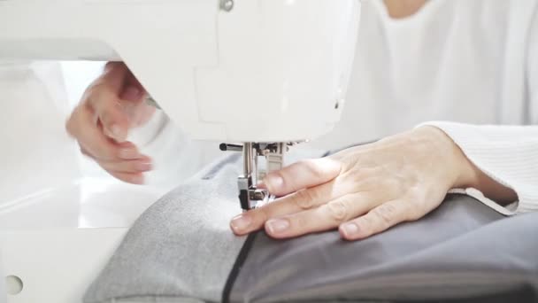 Unrecognizable woman s hands sewing at a sewing machine - Materiał filmowy, wideo