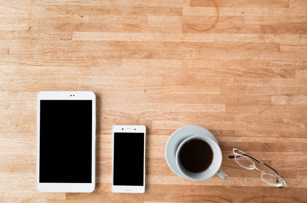 smartphone και tablet στο ξύλινο γραφείο με κανείς δεν - Φωτογραφία, εικόνα