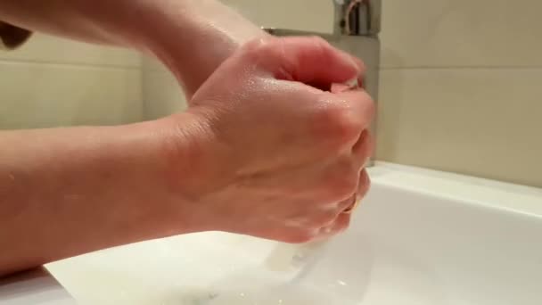 蛇口の下に彼女の手を洗う女性 - 映像、動画