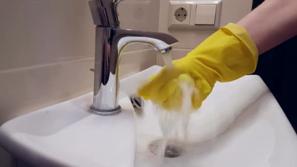 Hands in gloves wash the sink in the bathroom - Footage, Video