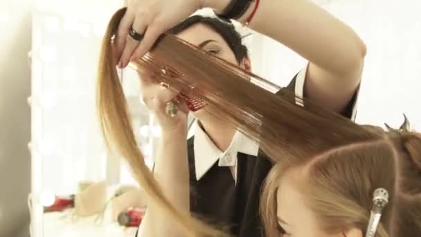 Hairdresser combing female hair and cutting with professional scissors in hairdressing salon. Close up haircutter making female haircut with scissors in beauty salon. - Séquence, vidéo