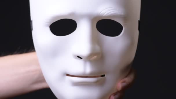 Mano de hombre joven sosteniendo máscara blanca
 - Metraje, vídeo