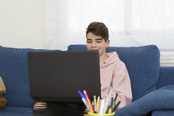 подросток с ноутбуком дома в гостиной
 - Фото, изображение