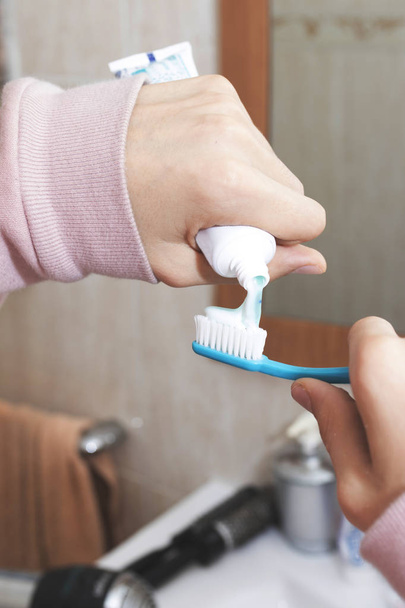 manos con pasta de dientes y cepillo de dientes
 - Foto, Imagen