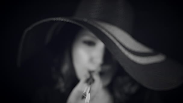 Dívka kouří na černém pozadí - Záběry, video