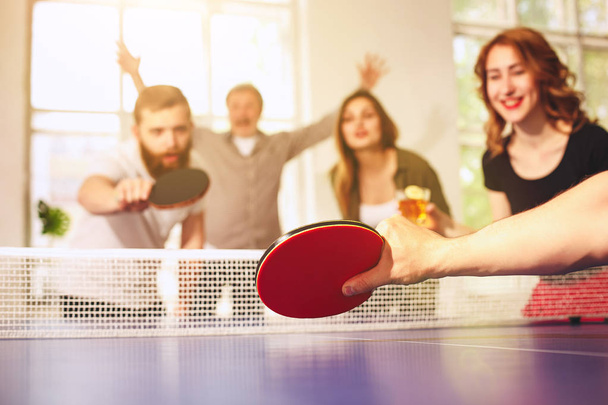 Grupo de jovens amigos felizes jogando ping pong tênis de mesa
 - Foto, Imagem