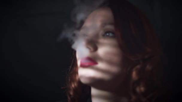 Girl smoking on black background - Materiał filmowy, wideo