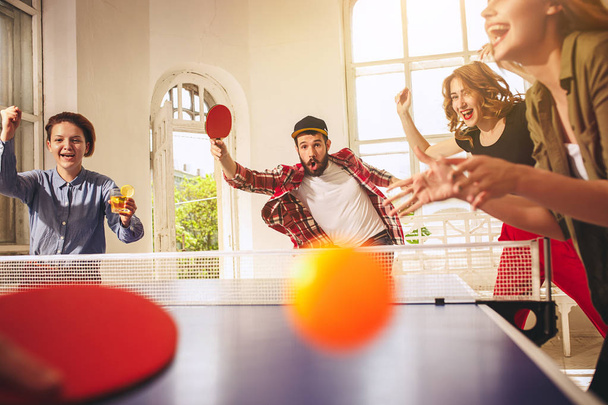 Group of happy young friends playing ping pong table tennis - 写真・画像