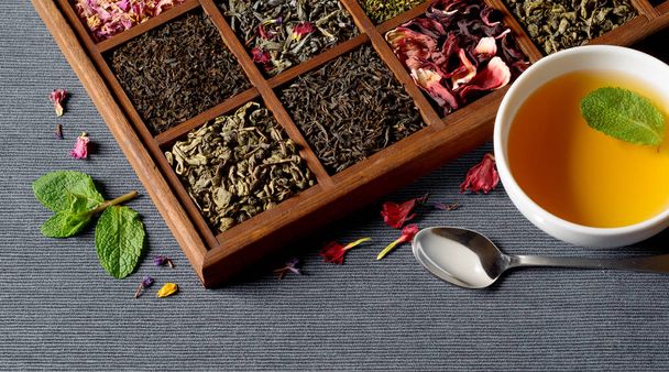 Асортимент сухого чаю в дерев'яній коробці
 - Фото, зображення