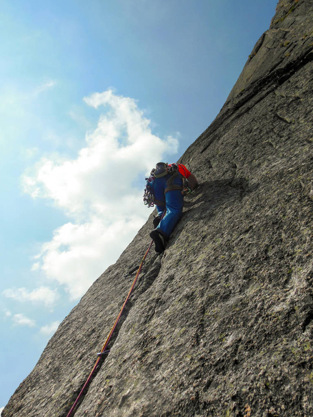 alpinista vestido com cores brilhantes em uma rota de escalada de granito íngreme nos Alpes
 - Foto, Imagem