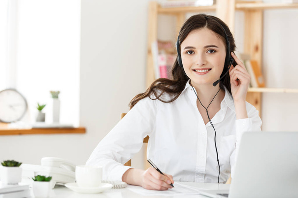 Call Center Concept: Portret van gelukkig lachend vrouwelijke klant ondersteuning telefoon operator op werkplek. - Foto, afbeelding