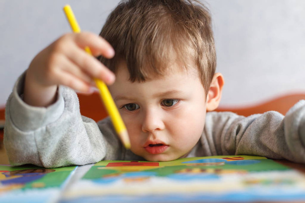 Kisfiú, színes ceruza rajz. Aranyos fiú, aki színes ceruzák. - Fotó, kép