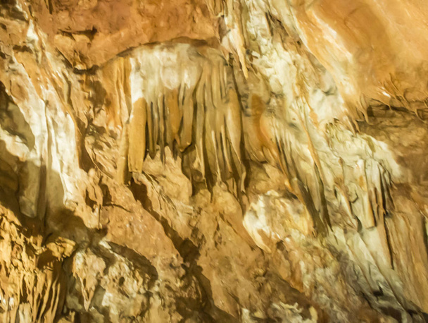 Stalactieten en stalagmieten in een grot. Natuurlijke stevige rock achtergrond Crimea - Foto, afbeelding