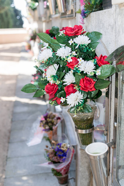 Detalle de un ramo de flores en un cementerio
 - Foto, imagen