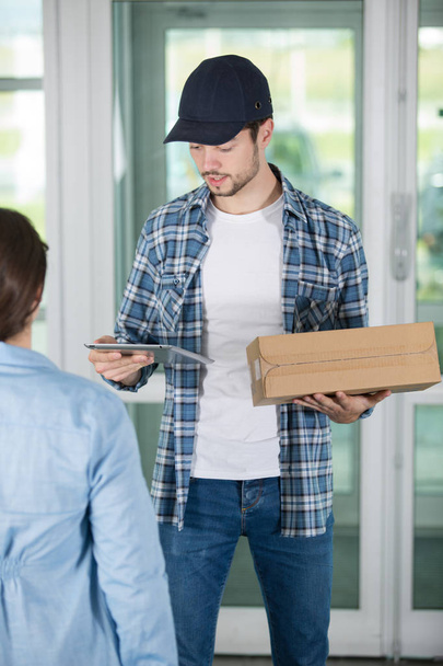 young delivery man holding a cardboard - Photo, Image