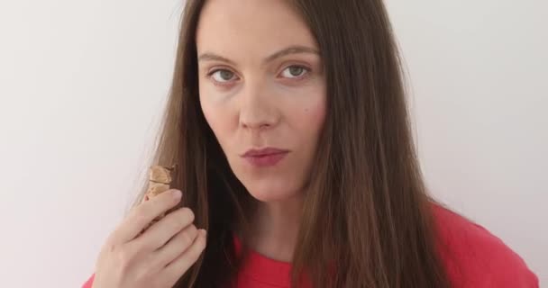 Cute girl chewing chocolate - Кадри, відео