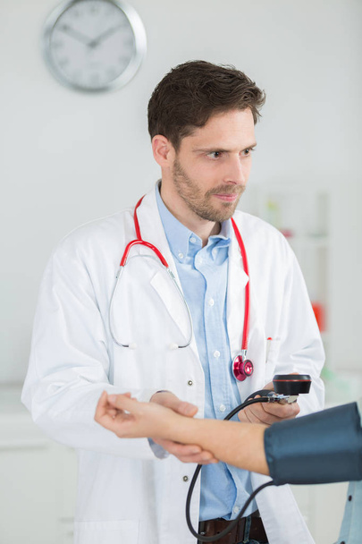 врач проверяет артериальное давление сфигмоманометром
 - Фото, изображение