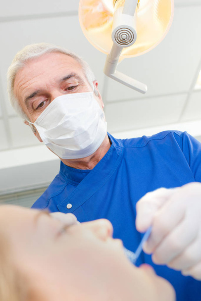 senior dentist taking care of females patients teeth - Fotó, kép