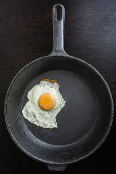 poêle à frire avec des œufs frits sur un fond sombre en bois
 - Photo, image