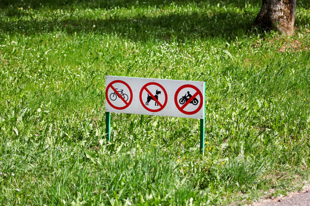 A forgalom jel / jelek vagy nem kisállat kutyák hulladék jelképe, kerékpár- és motorkerékpár nem engedélyezett a fű nyilvános parkban / tiltott és figyelmeztető jelek tiltó / ökológia és a természet megőrzése. - Fotó, kép