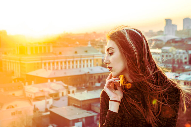 Beautiful girl  on the rooftop watching sunset  - Фото, изображение