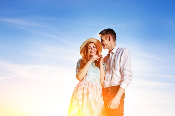 un jeune couple debout sur un fond de ciel bleu
. - Photo, image
