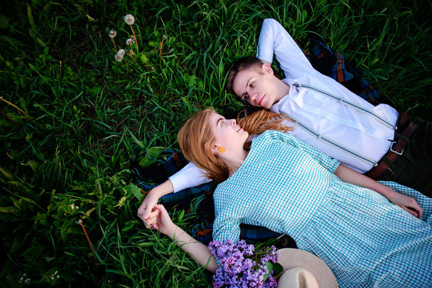Jong (echt) paar liggen op het gras en ontspannen, van bovenaf bekijken. - Foto, afbeelding