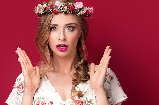 Beauty fashion portrait of blonde caucasian woman with flowers on head. Girl in glamour makeup posing on colorful background. - Foto, imagen