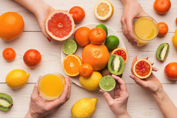 Hands choosing citrus fruits, top view - Photo, Image