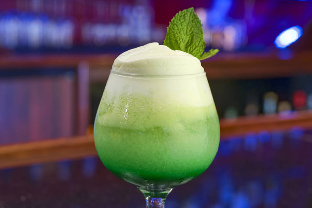 Cold green cocktail with mint leaf and thick foam - Фото, изображение